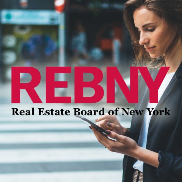 Real Estate Board of New York and a woman looking at her phone on a city street corner.