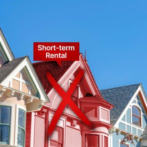 A short-term rental home is x'ed out, representing a ban on such property types.