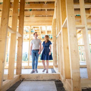 A couple walks through a house under construction