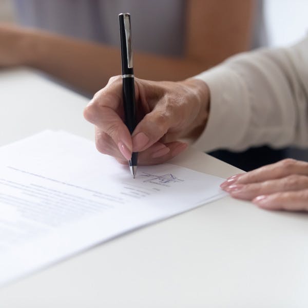 A woman signs a mortgage document.
