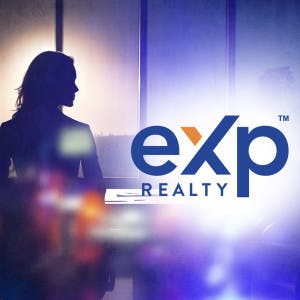 eXp Realty logo against a backdrop of a woman's silhouette in a conference room.