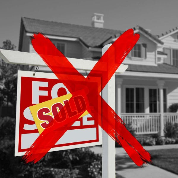 A "sold" sign in front of a home is x'ed out.