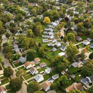 An aerial view of suburban homes and trees.