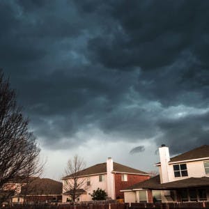 Storm clouds roll over suburban homes.