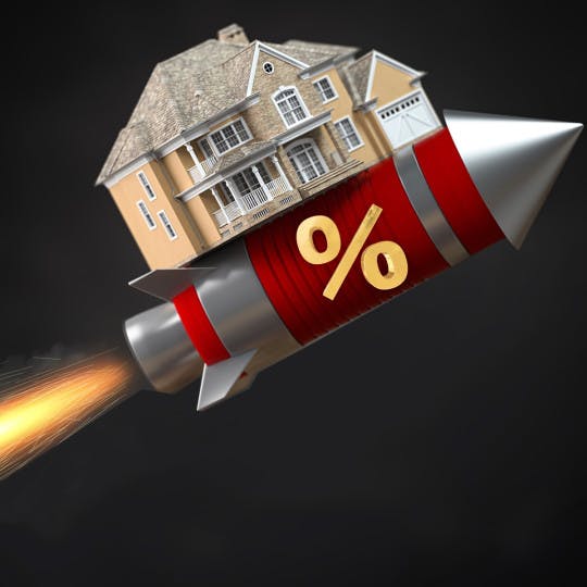 A house is strapped to a rocketship, representing surging mortgage rates.