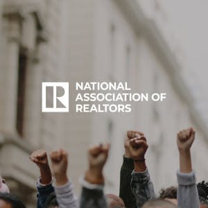 The National Association of Realtors logo against the backdrop of a protest.