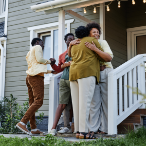 family embraces on steps of home
