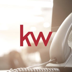 Keller Williams Realty logo and corded telephone on a desk