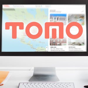 Tomo Real Estate search page on a desktop monitor