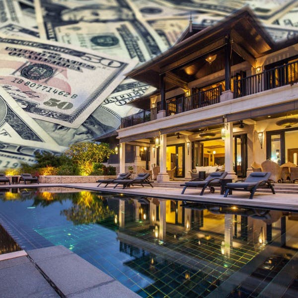 A luxury home surrounded by large bills.