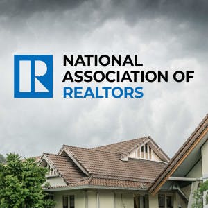 The National Association of Realtors logo against a backdrop of homes and a stormy sky.