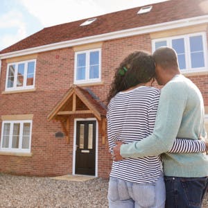 Couple hugging staring at house