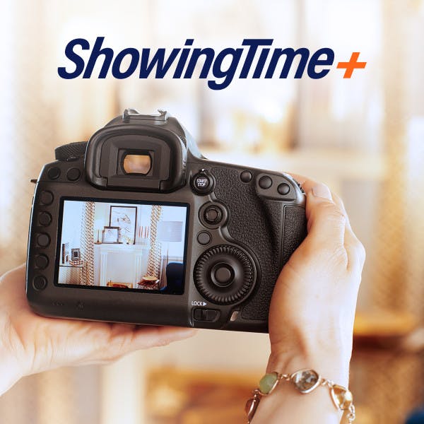 ShowingTime logo and person holding a camera to take picture of living room