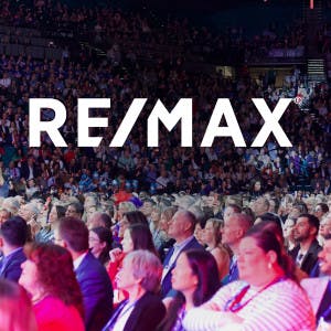 RE/MAX conference with people and RE/MAX logo overlayed above