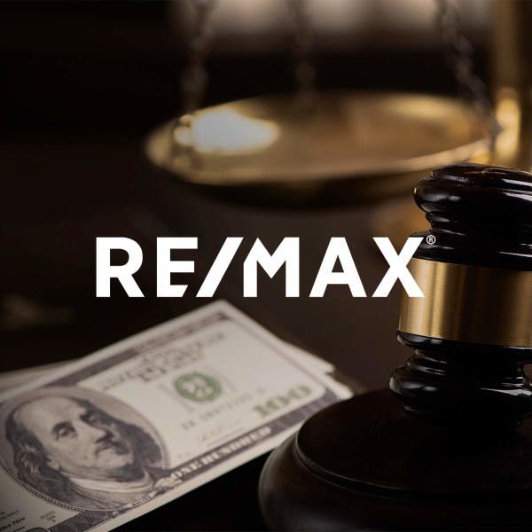 The RE/MAX logo against a backdrop of a gavel and money.