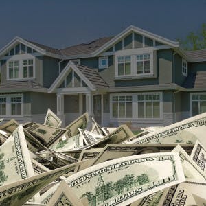 A pile of hundred-dollar bills in front of a house